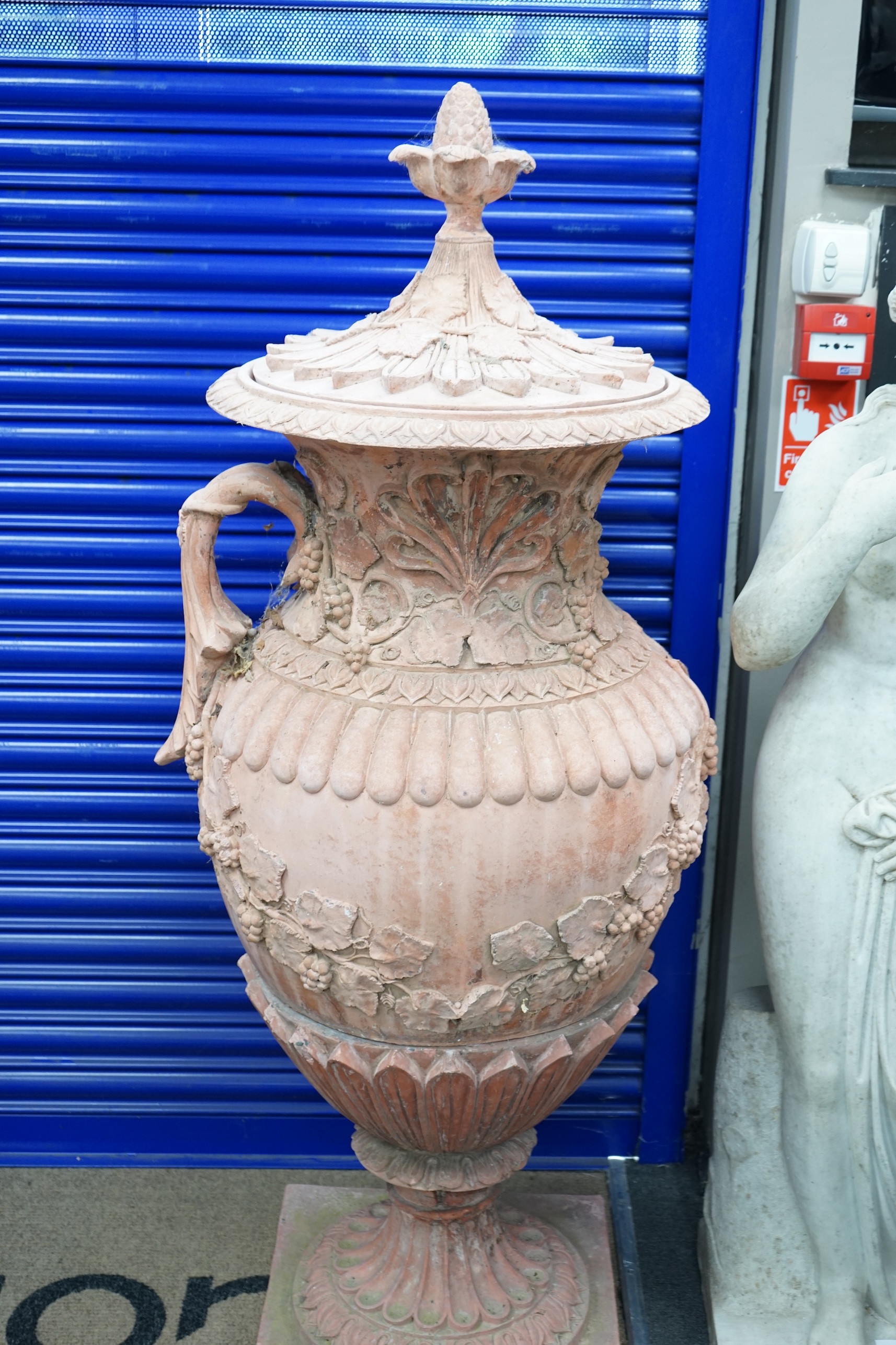 A pair of ornate terracotta urns and covers